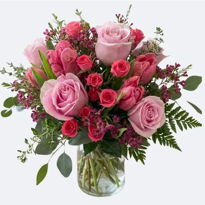 Pink Roses and Red Rose Bouquet in a Vase 1 A beautiful Pink Roses and Tulips Bouquet arranged in a glass vase with lush greenery.