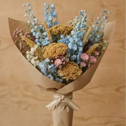 A rustic waxflower bouquet featuring delicate pastel blossoms and wild meadow greenery in a natural arrangement.