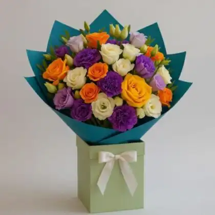 A vibrant multicolor rose bouquet featuring pink and orange roses with white lisianthus in a luxury hatbox.