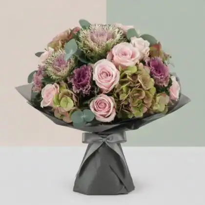 A vibrant purple kale bouquet combined with fresh greenery and seasonal blooms in a sophisticated arrangement.