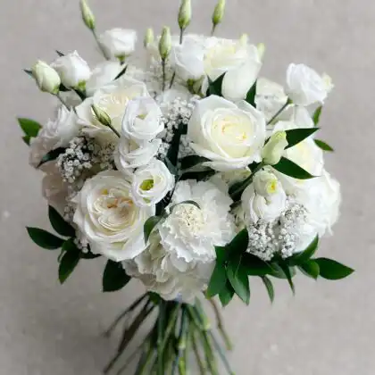 A stunning white carnation and rose bouquet arranged with fresh greenery for an elegant look.