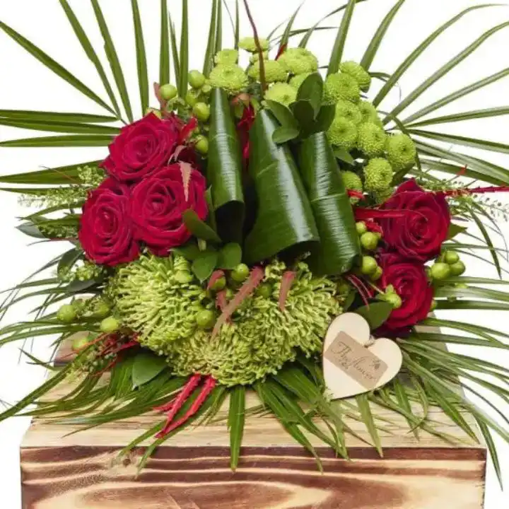 Vibrant Rose & Hypericum Burst 1 A hand-tied rose and hypericum bouquet featuring deep red petals and textured green berries in a glass vase.