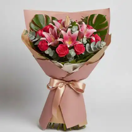 A luxury Pink Rose & Oriental Lily Bouquet wrapped in premium paper with monstera leaves and eucalyptus.