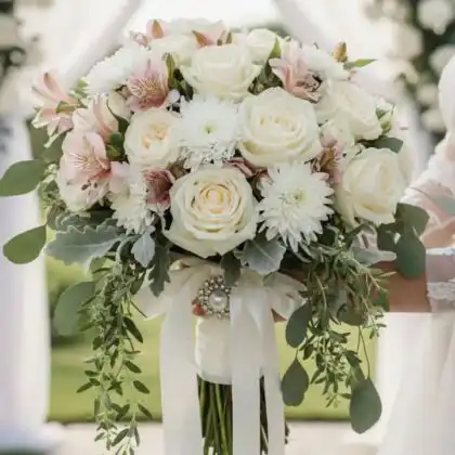 Hand-tied roses and alstroemeria bouquet arranged with fresh greenery in a stylish professional floral display.