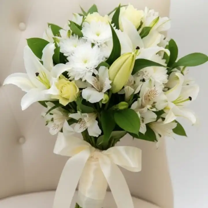 Elegant White Alstroemeria & Lily Bouquet 1 Hand-tied alstroemeria and lily bouquet with lush green leaves and a silk cream ribbon against a neutral background.